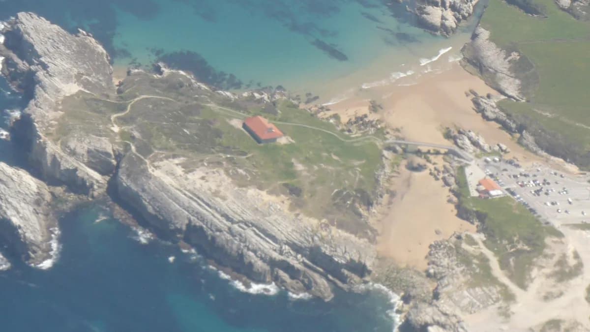 Playa e isla de la Virgen del Mar en la costa agreste de Santander